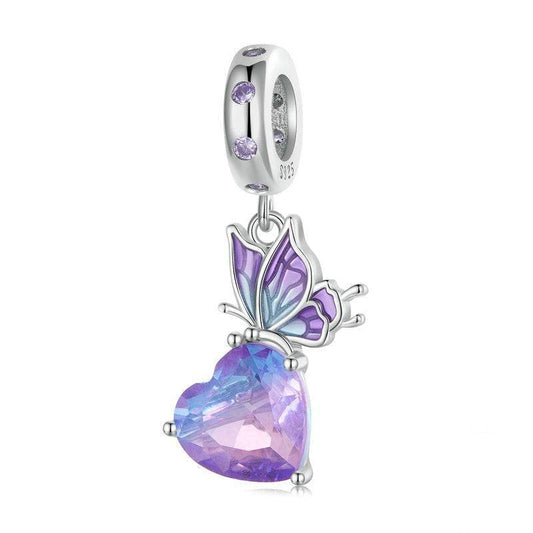 Crystal Butterfly Charm with a heart-shaped purple gemstone and silver detailing, perfect for adding magic and color to jewelry collections.