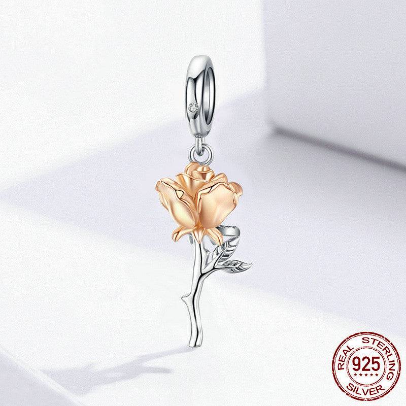 Gold rose charm on white background