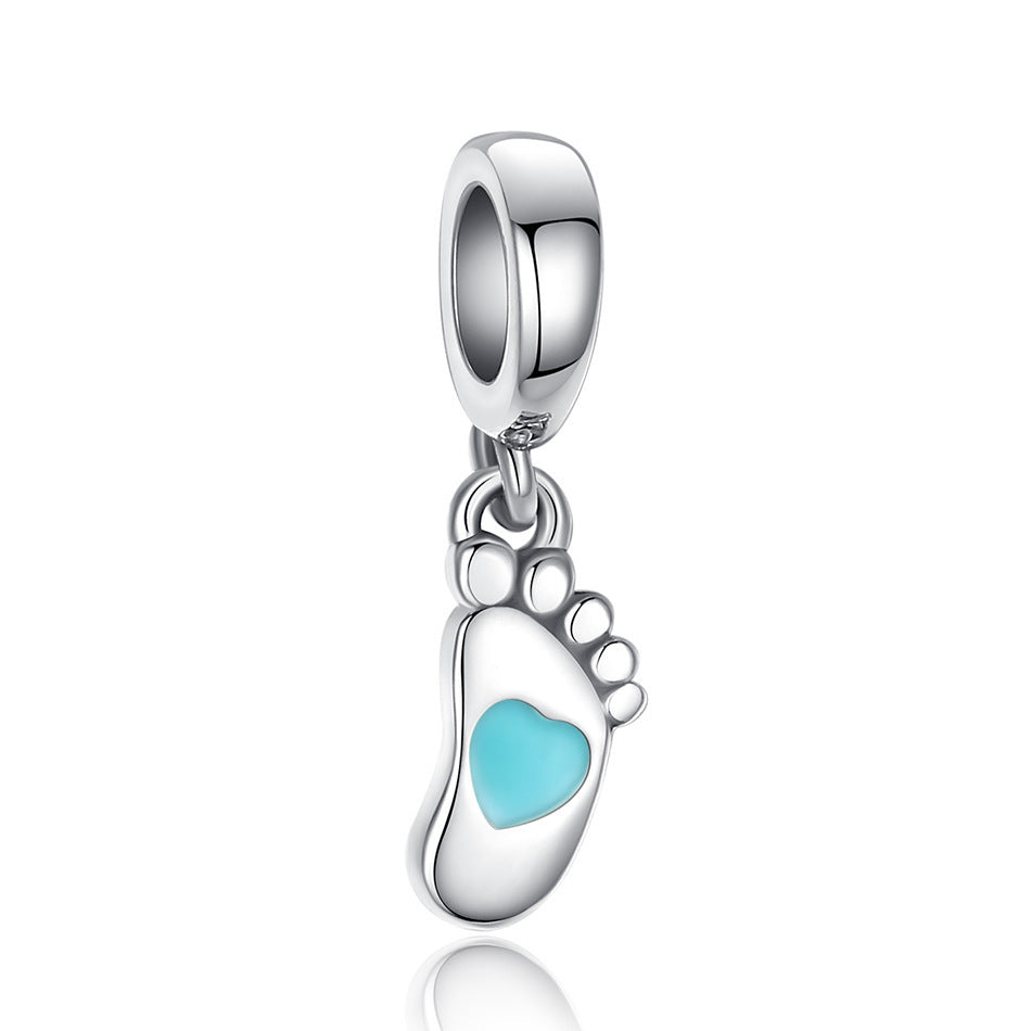 Sterling silver baby footprint charm with a turquoise heart accent, perfect for charm bracelets or necklaces. A sentimental keepsake for parents.