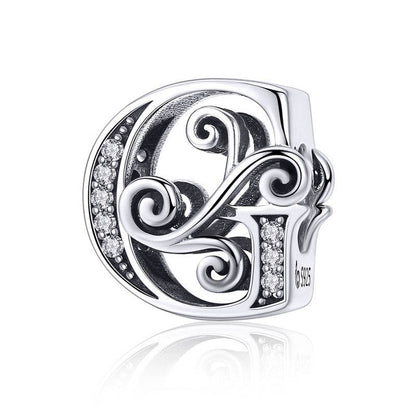 Ornate letter G charm with swirl design