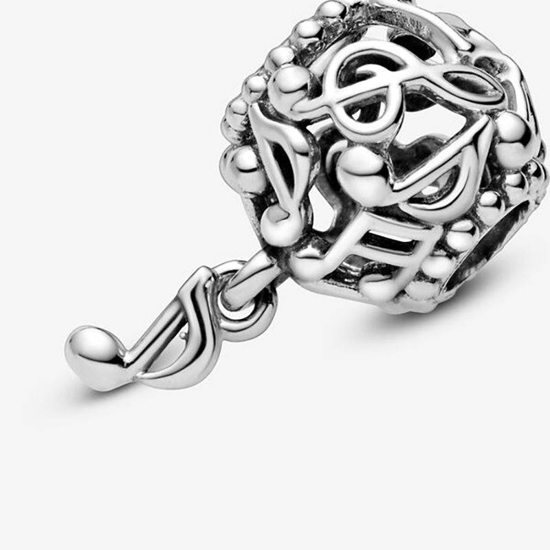 Close-up of a sterling silver musical note charm featuring delicate note designs, ideal for charm bracelets and jewelry collections.