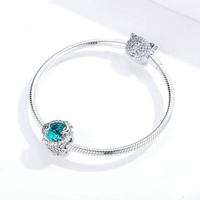 Silver bracelet adorned with an Aqua Glass Charm, highlighting its elegant craftsmanship and stylish appeal.