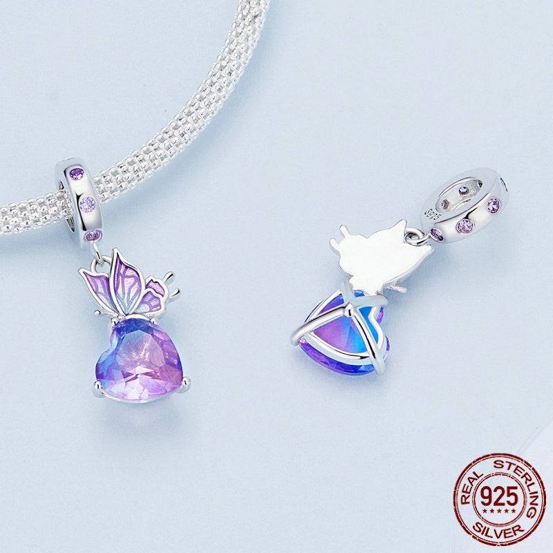 Sterling silver Crystal Butterfly Charm with a vibrant purple heart gemstone, shown from different angles to highlight its intricate design.