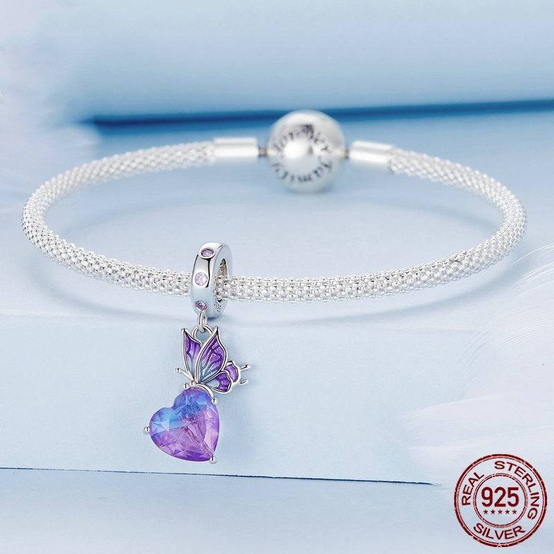 Elegant Crystal Butterfly Charm attached to a sterling silver bracelet, featuring a purple gemstone and delicate butterfly wings.