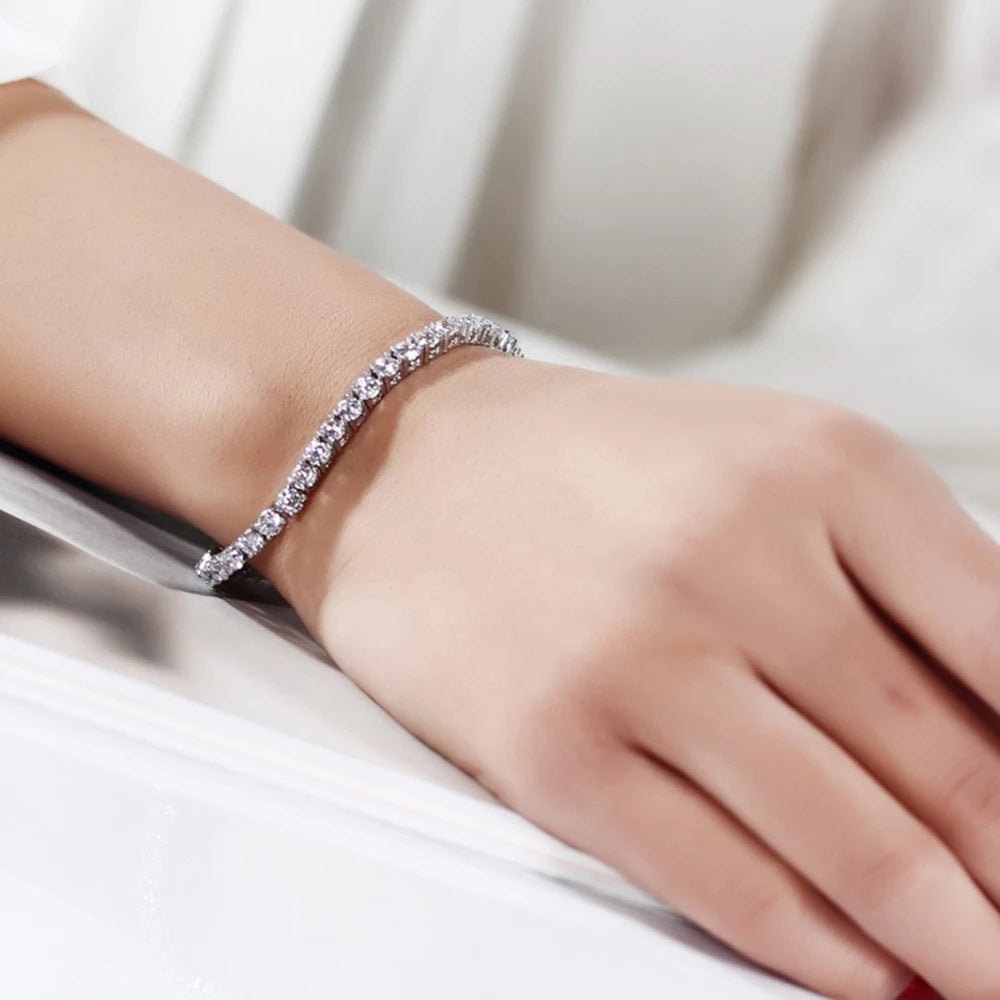 Silver tennis bracelet elegantly worn on a wrist.