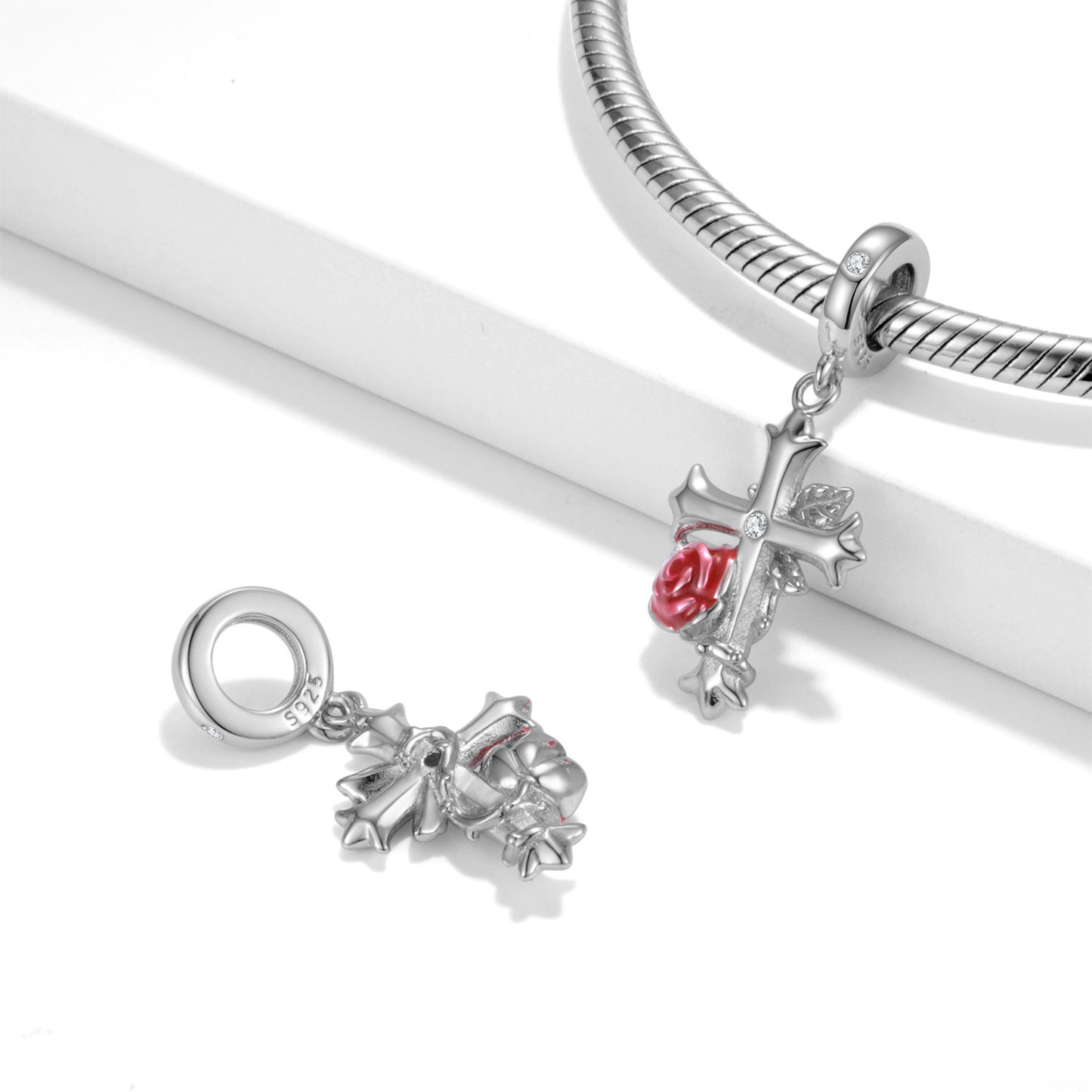 Elegant Rose Cross Charm displayed on a silver bracelet, featuring a red rose and silver cross. A stylish accessory for Gothic and vintage jewelry lovers.