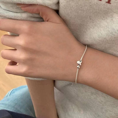 Heart Bead Silver Bracelet worn on a wrist, showcasing its elegant and minimalist design, ideal for daily wear or special occasions.