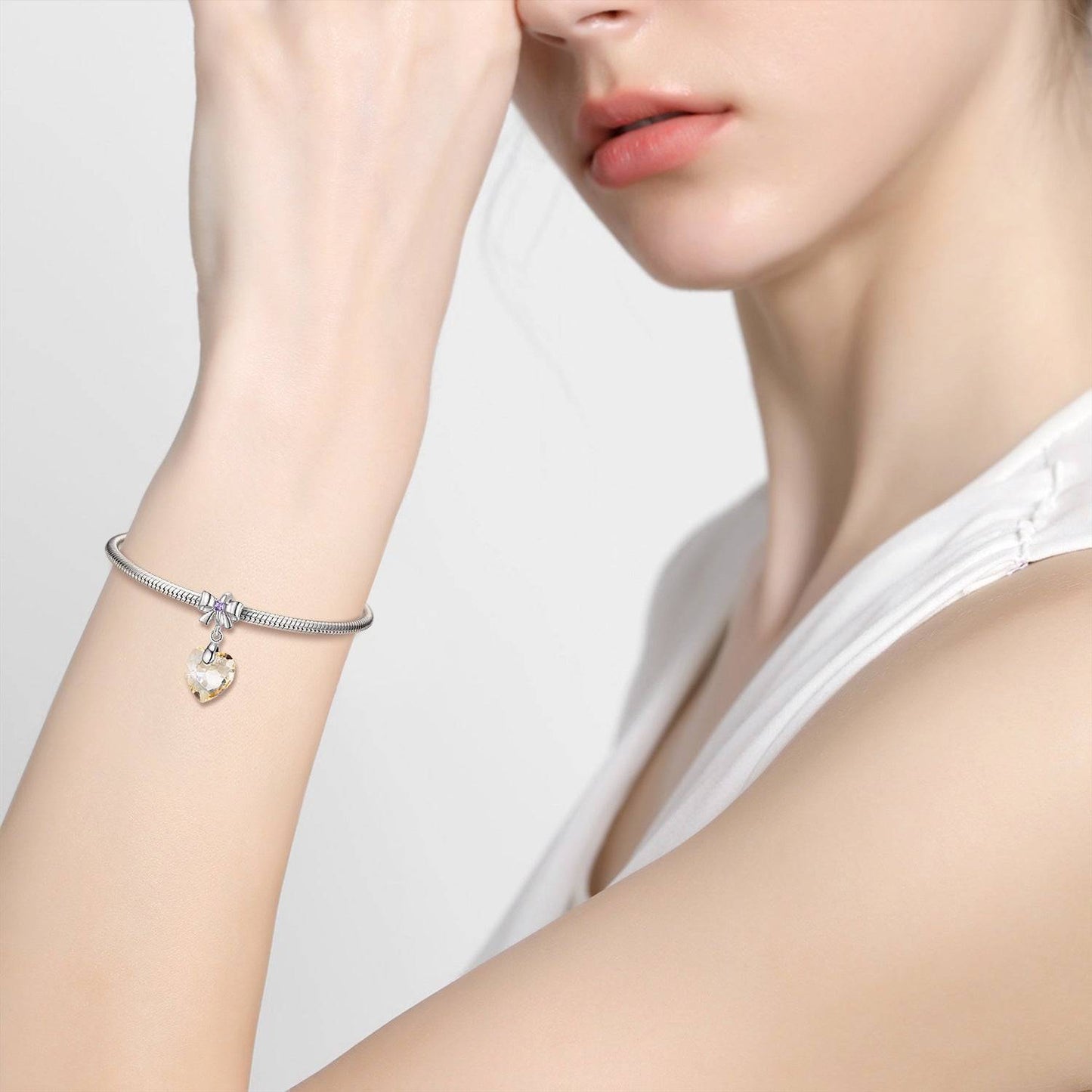 Model wearing a Golden Crystal Charm on a silver bracelet, showcasing its luxurious shine and stylish appeal. Perfect for any occasion.