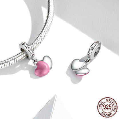 Sterling silver Pink Heart Tag Charm with pink enamel heart, shown alongside a silver bracelet for styling inspiration.