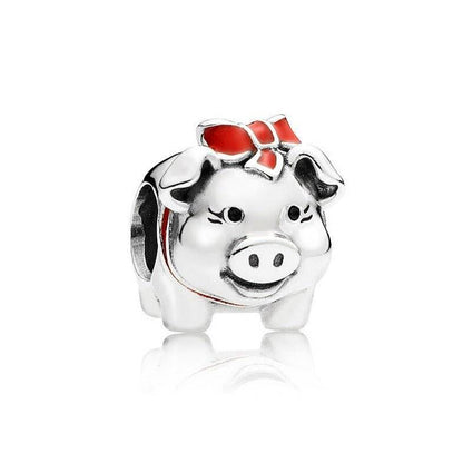 Silver pig charm with red bow detail